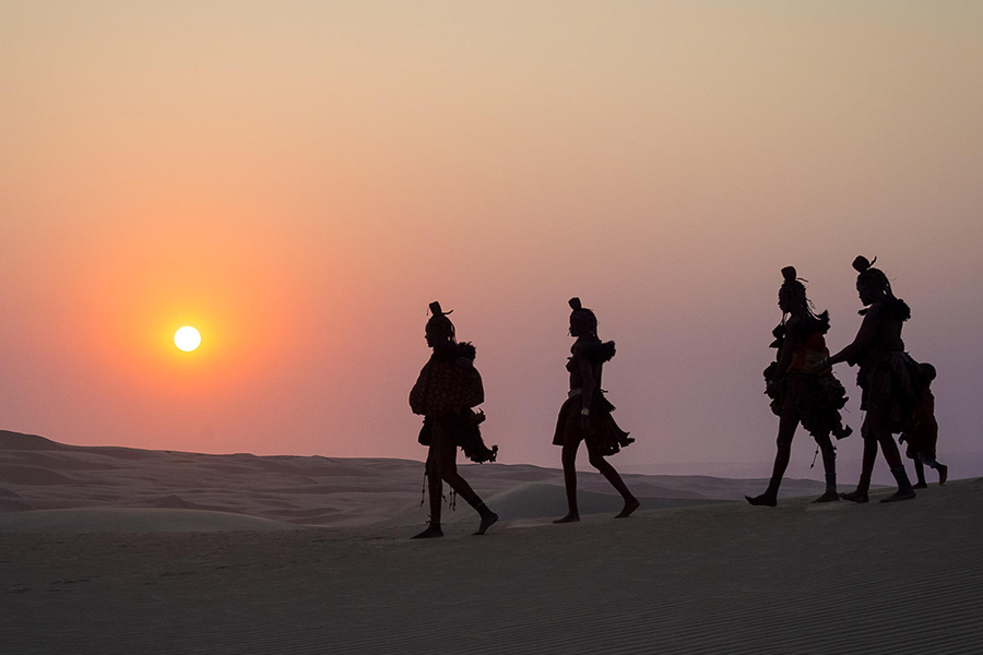 Local people walking in desert in Kunene wearing traditional dress