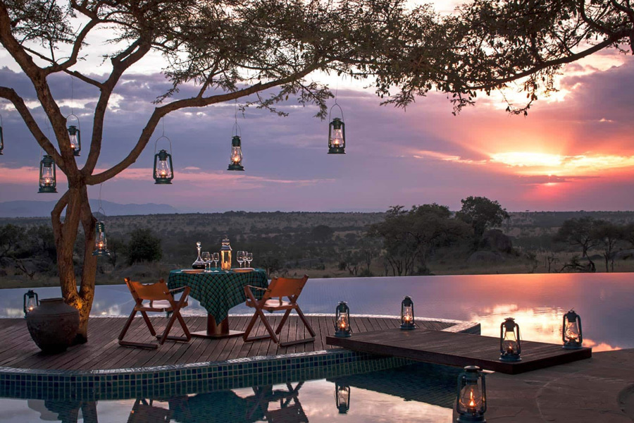 Luxury accommodation Four-Seasons-Safari-Lodge-Serengeti at sunset dining area at pool with view
